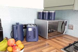 a microwave on a kitchen counter with fruit on the floor at 5 Star Homes- Free Wifi & Parking, Contractor & family friendly in Pallion