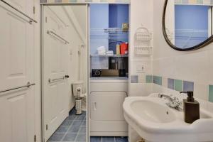 Un baño blanco con lavabo y espejo. en Cottage with water view and hot tub - Le pin blanc, en Baie-Saint-Paul 69 fotos más