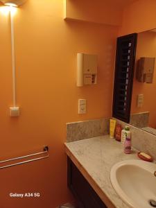 un bagno con lavandino e specchio di la tartane a La Trinité Altre 25 foto