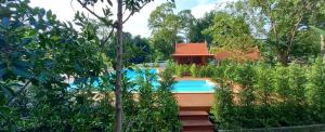 a swimming pool in a garden with a house at Pasak River Bungalow 1 in Sao Hai