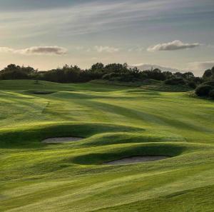 a green golf course with a hole in the grass at 5 Star Homes- Free Wifi & Parking, Contractor & family friendly in Pallion