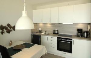 a kitchen with white cabinets and a table with a plate on it at Panorama Whg 25, 2 OG in Cuxhaven