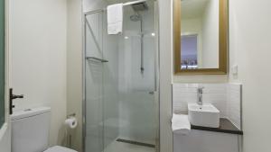 a bathroom with a glass shower and a sink at Shamrock 1 in Mount Hotham