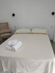 Una cama blanca con dos toallas encima. en Departamentos M&A 2, en Puerto Rico