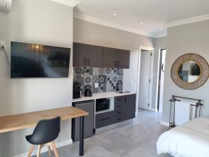 a kitchen with a desk and a bed in a room at Silver Views Guest Suite - No loadshedding! in Pretoria