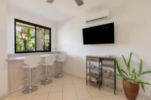 Μια τηλεόραση ή/και κέντρο ψυχαγωγίας στο Two Palms Ground Floor Unit Across From Beach