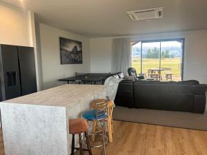a bedroom with a large bed and a table and chairs at The Opuha House in Ashwick Flat