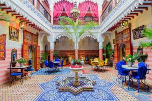 una hall con tavolo e sedie in un edificio di Riad bleu du Sud a Marrakech