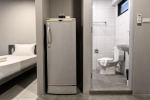 a bathroom with a refrigerator next to a toilet at Stay Wanglang in Bangkok +21 photos