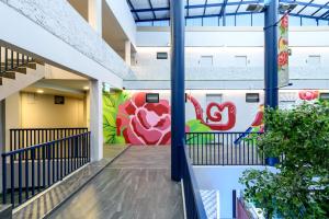 a hallway in a building with a mural on the wall at Stay Wanglang in Bangkok