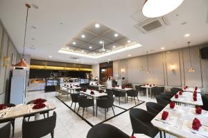 a dining room with tables and chairs and a kitchen at Hotel Laonzena in Daegu