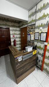 a reception desk in a building with a sign on the wall at check in hotel in Brinchang