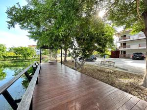 a wooden boardwalk in a park with trees and water at DD Boutique Resort in Ban Wat Pa