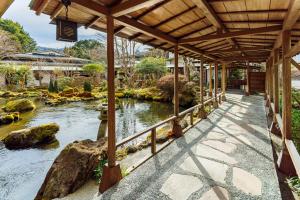 a garden with a pond and a wooden walkway at Yoshimatsu in Hakone