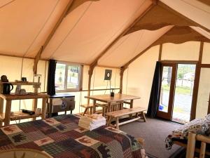 ein Zimmer mit einem Bett und einem Tisch in einem Zelt in der Unterkunft Howling Wolf Resort in Seward