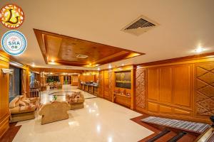 un soggiorno con boiserie e una grande stanza di The Ligor City Hotel a Nakhon Si Thammarat