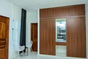 een keuken met houten kasten en een tafel en stoelen bij New York in Lomé +6 foto's