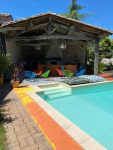 - une piscine avec des chaises et un pavillon dans l'établissement COUNTRY HOUSE La VILLAE, à Sieurac