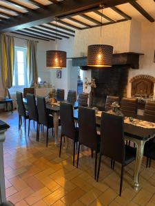 une salle à manger avec une table et des chaises et une cheminée dans l'établissement COUNTRY HOUSE La VILLAE, à Sieurac