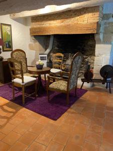 une chambre avec des chaises, une table et une cheminée dans l'établissement COUNTRY HOUSE La VILLAE, à Sieurac