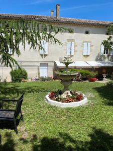 une fontaine au milieu d'une cour avec un banc dans l'établissement COUNTRY HOUSE La VILLAE, à Sieurac