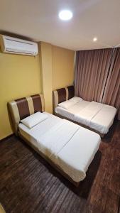um quarto com duas camas em um quarto em Cute Hotel em Yong Peng
