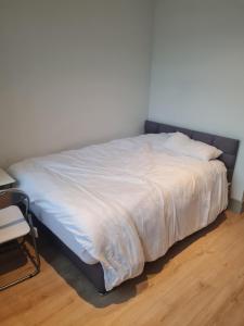 1 cama en un dormitorio con colcha blanca en A Stylish New Build Studio Flat in Uxbridge London, en Uxbridge