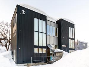 un bâtiment noir dans la neige dans l'établissement Sekka Ni Chalet, à Kutchan
