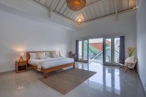 a bedroom with a bed in a room with glass doors at Olivia Estate by Villas Direct Bali in Seminyak +58 photos
