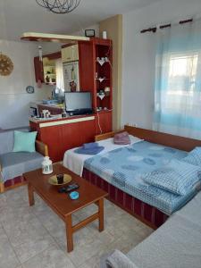 a room with a bed and a couch and a table at Tasos in Nea Potidaea