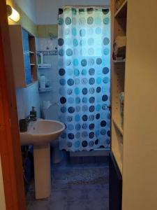 a bathroom with a shower curtain and a sink at Tasos in Nea Potidaea