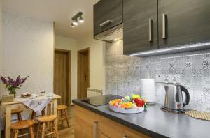 a kitchen with a bowl of fruit on a counter at Baranówka in Muszyna
