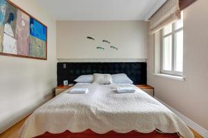 a bedroom with a large bed with a black headboard at Willa Morska Deluxe by Grand Apartments in Sopot