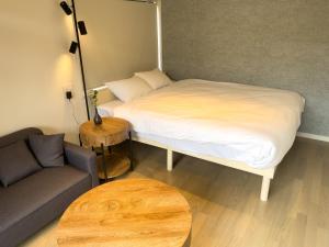 une chambre avec un lit, un canapé et une table dans l'établissement リノベーションされた一軒家で富士山と自然 BBQを満喫 villa voyage, à Azagawa