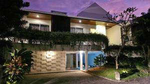 a building with a pathway leading to the front door at Villa Omah Bali in Uluwatu