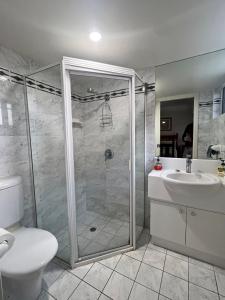 Un baño con ducha, inodoro y lavabo. en Ocean Shores Apartment 13, en South West Rocks