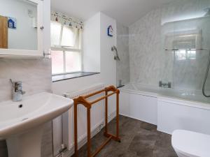 a bathroom with a sink and a tub and a toilet at Panteg Cottage, Newport in Newport Pembrokeshire +20 photos