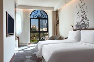 a hotel room with two beds and a window at The Heritage Hotel, Autograph Collection, Downtown Dubai in Dubai