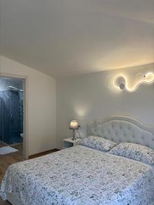 a bedroom with a bed with a white comforter at La Grotta 2 Bedrooms in Urzulei