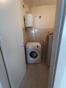 a small bathroom with a washing machine in it at Apartman Slatina in Tuzla