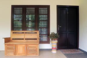 a door to a house with a potted plant in front of it at Bethel Homestay Thiruvallam in Trivandrum