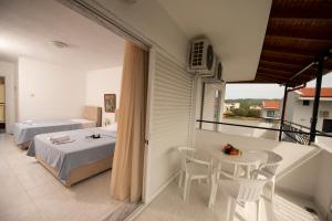 a bedroom with a bed and a table and a balcony at Estia hotel in Fourka