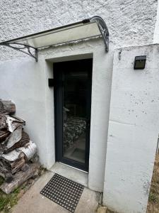 a door to a building with a pile of logs at Studio neuf rez de jardin dans chalet individuel in Thollon +5 photos