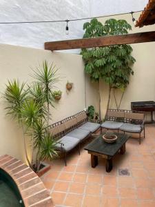 a patio with benches and a table and plants at Casa Vallejo in San Miguel de Allende