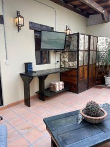 a living room with a television and a table at Casa Vallejo in San Miguel de Allende