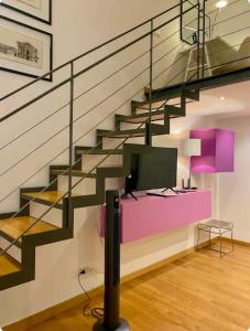 a living room with a staircase with a tv at Loft Crocetta in Turin