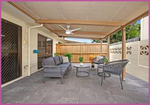 a patio with chairs and a ceiling fan at Queens Road 14/80 in Aitkenvale