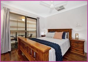a bedroom with a large bed and a balcony at Queens Road 14/80 in Aitkenvale