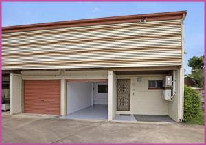 a building with a garage with a red door at Queens Road 14/80 in Aitkenvale +3 photos