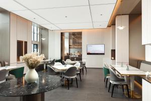 un ristorante con tavoli, sedie e schermo di Atour Hotel Changsha South Station Guitang Metro Station a Changsha